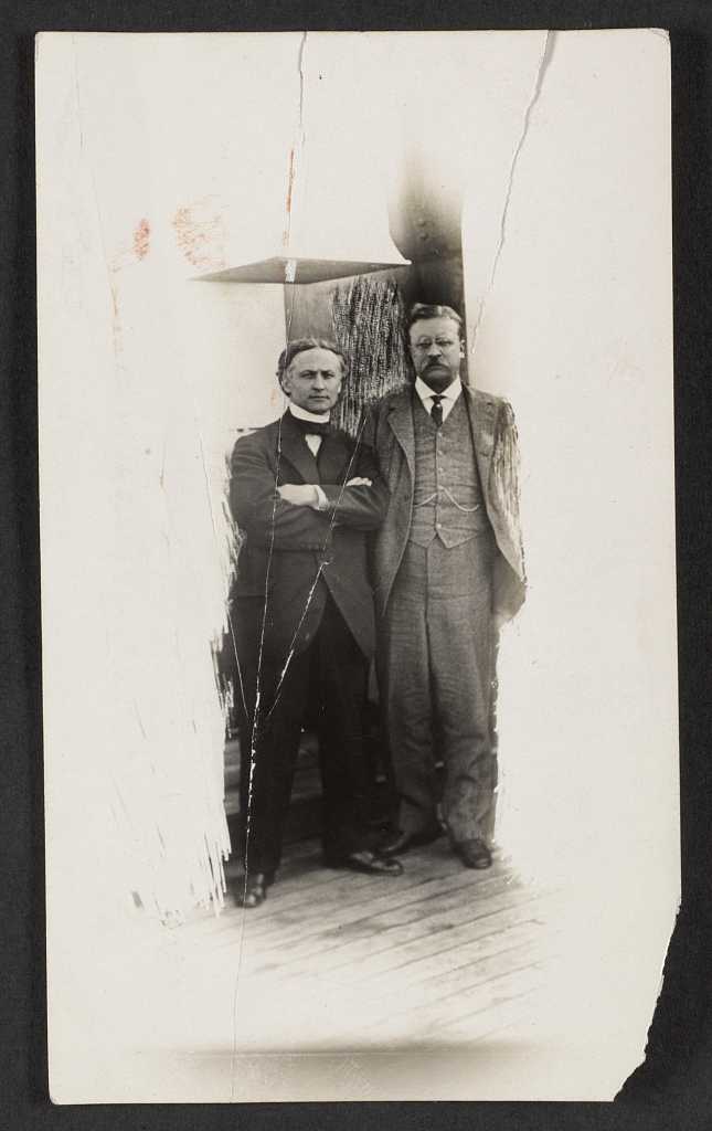 Old black and white photo of Harry Houdini standing next to President Teddy Roosevelt.